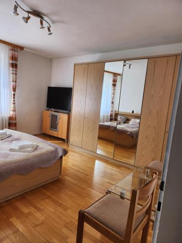 a bedroom with a bed and a table and a mirror at Casa Mea Privatzimmer 2 in Klingenbach
