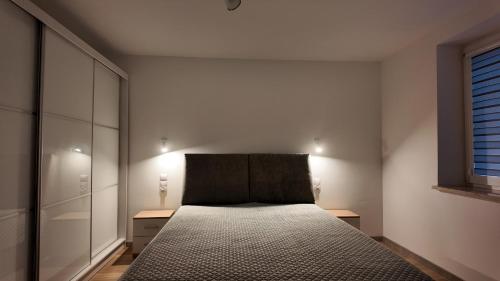 a bedroom with a bed with a headboard and a window at Dom pośrodku Roztocza in Oseredek