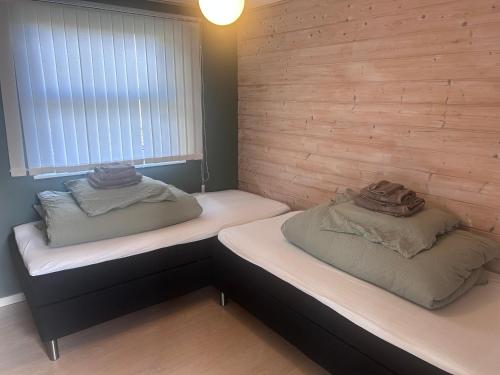 two beds sitting in a room with a window at Herning, Sunds Lake Beautiful View & Spa 105 m2 in Sunds