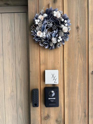 a wreath on a wooden door with a remote control at XYZ Niseko in Niseko