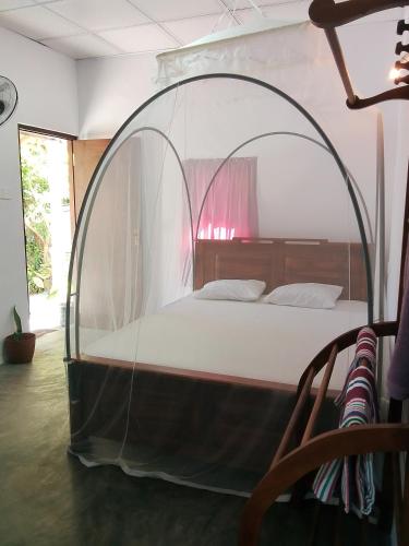 ein Schlafzimmer mit einem Bett in einem gewölbten Rahmen in der Unterkunft Binu Home stay in Dikwella