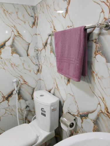ein Badezimmer mit Toilette und einem lila Handtuch in der Unterkunft Binu Home stay in Dikwella