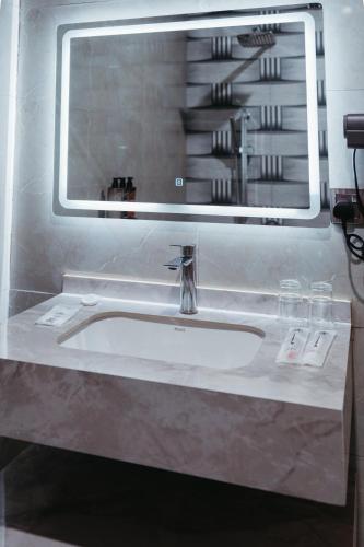a bathroom sink with a large mirror above it at Elephanto Hotel LTD in Zanzibar City