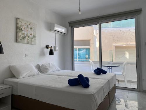 a bedroom with a bed with two blue pillows on it at Midtown Napa Apartments in Ayia Napa