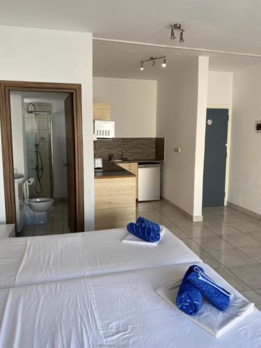 a bedroom with a white bed with blue towels on it at Midtown Napa Apartments in Ayia Napa