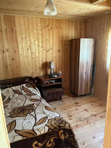 a bedroom with a bed and a wooden floor at Дом в Бахмаро in Chʼkhakoura