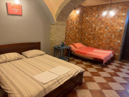 a bedroom with two beds and a table in a room at Срібний ключ in Mukacheve