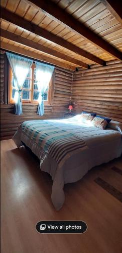 a bedroom with a large bed in a room with windows at Cabaña Alamos Altos in Belén de Escobar
