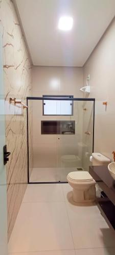 a bathroom with a glass shower and a toilet at Chalé Vertente da Canastra in São Roque de Minas