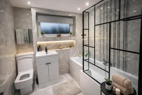 a bathroom with a toilet and a sink and a shower at Stylish 4 Bed House, Free Parking, Close to M4 Newport in Newport