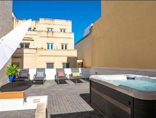 a hot tub on the roof of a building at Villa Luciano - Rooftop Jacuzzi, BBQ, Billiards & Steps from Sea in Sliema