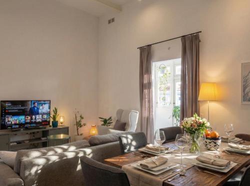 a living room with a table and a couch at Villa Luciano - Rooftop Jacuzzi, BBQ, Billiards & Steps from Sea in Sliema