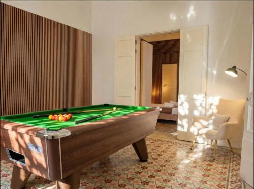 a pool table in a living room with a pool at Villa Luciano - Rooftop Jacuzzi, BBQ, Billiards & Steps from Sea in Sliema