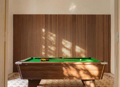 a green pool table in a room with a wall at Villa Luciano - Rooftop Jacuzzi, BBQ, Billiards & Steps from Sea in Sliema