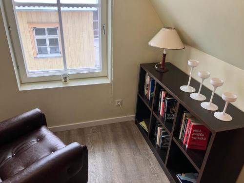 Una sala de estar con una estantería con una lámpara y un sofá. en City View Loft, en Viljandi