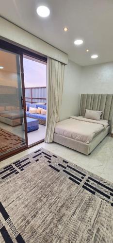 a bedroom with a bed and a large window at Al Barari Farm & Resorts Al Ain in ‘Ayn al Fayḑah