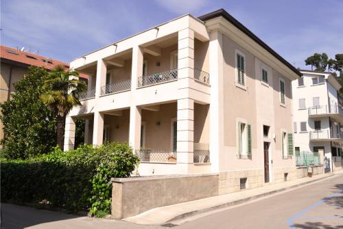 a large white building with a balcony on a street at Villa Olivieri 1928 in Ascoli Piceno