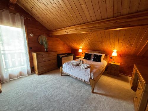 a bedroom with a bed in a wooden cabin at Chalet Tramontane, gîte tout confort in Xonrupt-Longemer