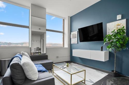 a living room with a couch and a tv at CozySuites At Presshouse in Pittsburgh