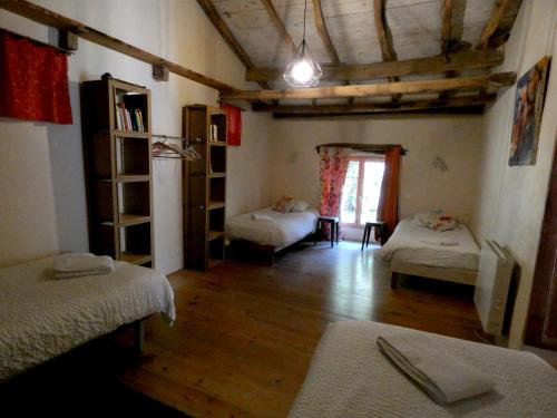 a room with two beds and a wooden floor at Domaine de La Maison d'Aum in Bourrou