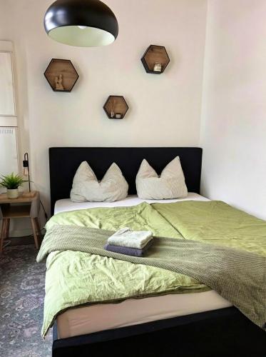 a bedroom with a bed with a green comforter at Traumlage! 3-Etagen Apartment direkt im Zentrum in Neumünster