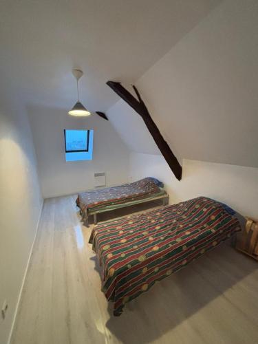 a room with three beds in a attic at Appartement Numéro 3, centre chateau-renault in Château-Renault