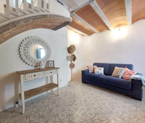 a living room with a blue couch and a mirror at Casa el far Peñíscola in Peniscola