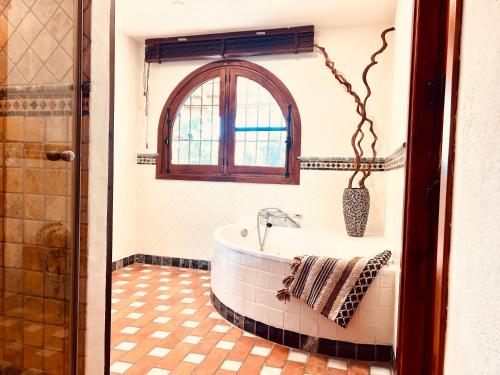 a bathroom with a tub and a window at Boutique Finca Stay in Nature in Mijas