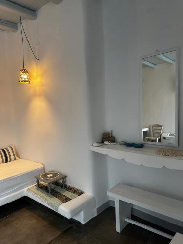 a white room with a bed and a mirror at Astra Serifos in Livadi