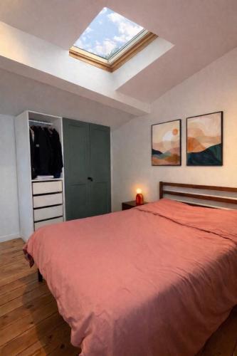a bedroom with a bed and a skylight at L'Atelier Saint Michel in Bordeaux