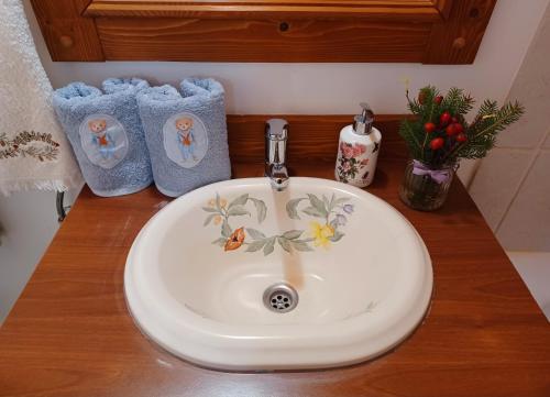 a bathroom counter with a sink and two towels at Fenyő Kuckó in Bodony