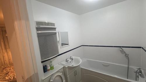 a bathroom with a toilet and a tub and a sink at 2 bed room , ensuite Flat close to Heathrow, Windsor , Langley in Langley Marish