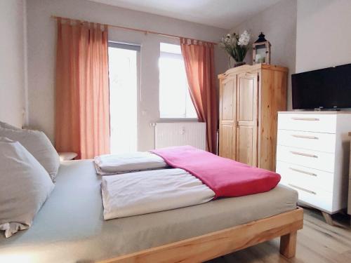 a bedroom with a bed and a dresser at Ferienwohnung Gessert in Querfurt
