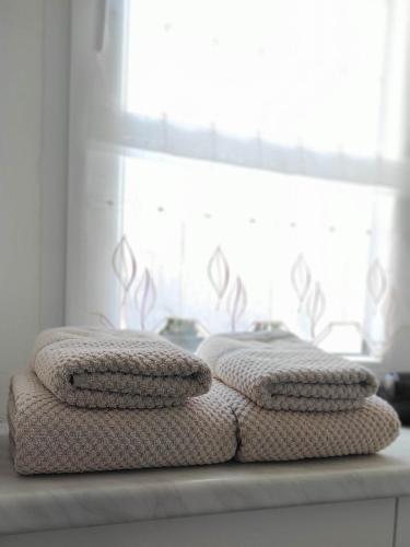 two stacks of towels sitting on a counter in front of a window at Ferienwohnung Gessert in Querfurt