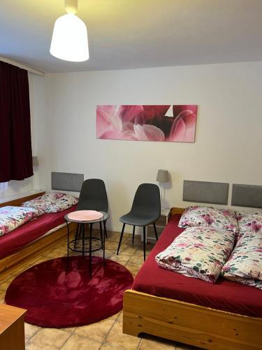 two beds in a room with a table and chairs at Pokoje in Duszniki Zdrój