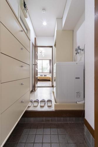 a bathroom with two pairs of shoes on the floor at Kunark KM102 Stay in Kokubunji