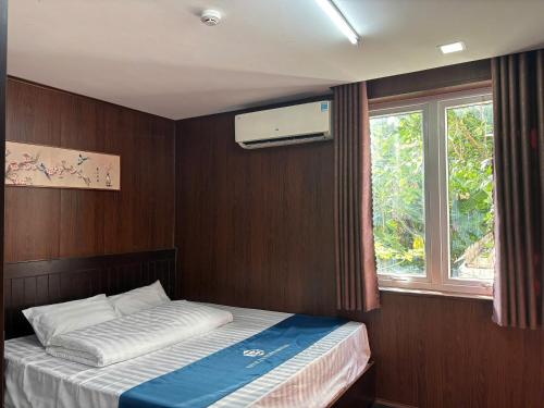 a small bedroom with a bed and a window at Blue Luxury Hotel & Spa in Danang