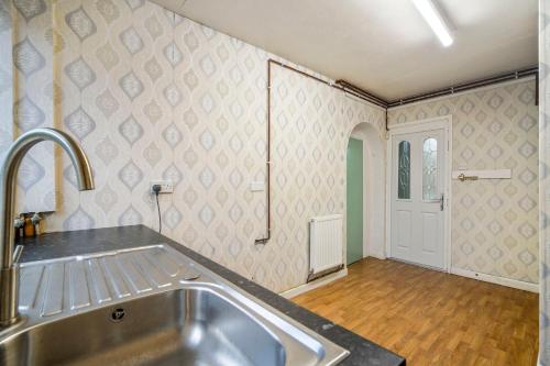 a kitchen with a sink and a counter top at Spacious 4-Bed House, & Prime Location Solihull in Olton