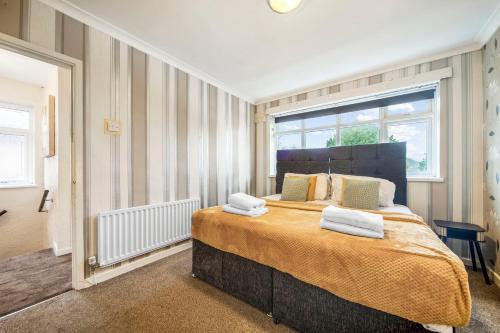a bedroom with a large bed with towels on it at Spacious 4-Bed House, & Prime Location Solihull in Olton