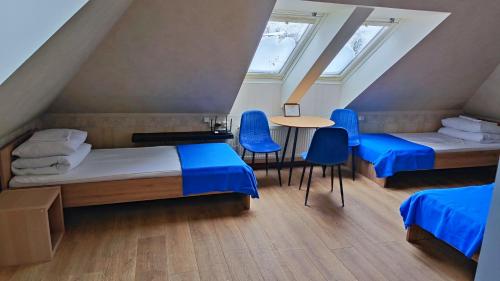 a room with two beds and a table and chairs at Bed&Blues in Vilnius