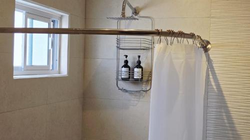 a bathroom with a shower with a white shower curtain at Habitacion Cedro in Saltillo