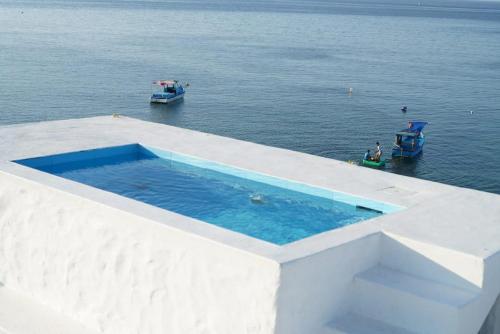 a swimming pool on the edge of a building in the water at Windy Villa Phú Quý in Cù Lao Thu
