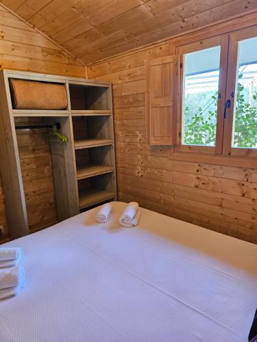a bedroom with a bed in a wooden cabin at Camping La Ribera Salada in Ogern