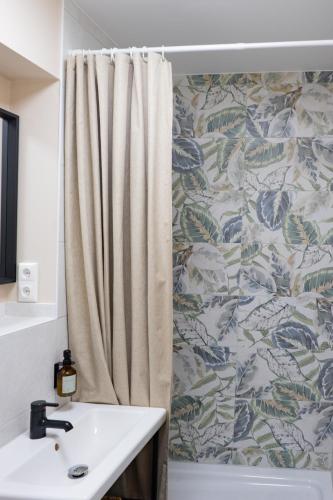 a bathroom with a shower curtain and a sink at Pension Trent in Trent
