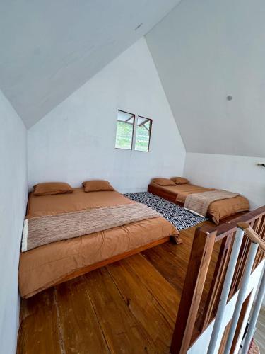 a bedroom with two beds in a attic at Pijar Jingga Cabin in Diyeng