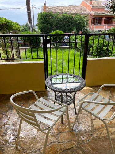 two chairs and a table and a table and chairs on a balcony at Nafsikas apartment 2 in Kanoni