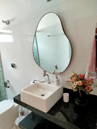 a bathroom with a sink and a mirror at Casa da Thalita in Pirenópolis