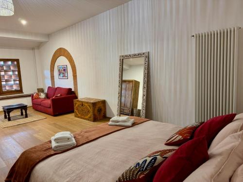 a bedroom with a large bed and a red couch at La Casa Gialla in Lucca