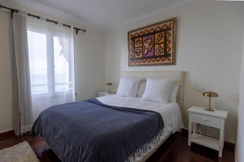 a bedroom with a bed with a blue comforter at Formosa Beach Apartment Vista Mar a 2 Minutos da Praia in Funchal