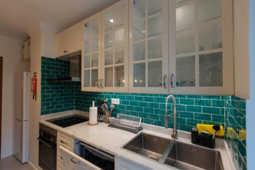 a kitchen with a sink and green tile at Formosa Beach Apartment Vista Mar a 2 Minutos da Praia in Funchal
